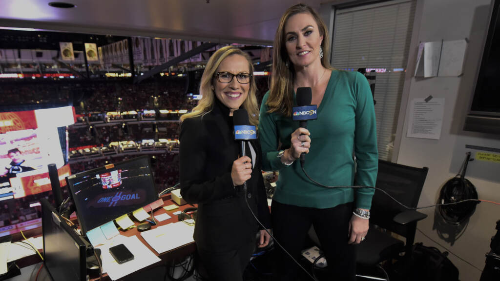 Blues Blackhawks Hockey Kate Scott, left, and AJ Mleczko stand holding mics in a sports booth