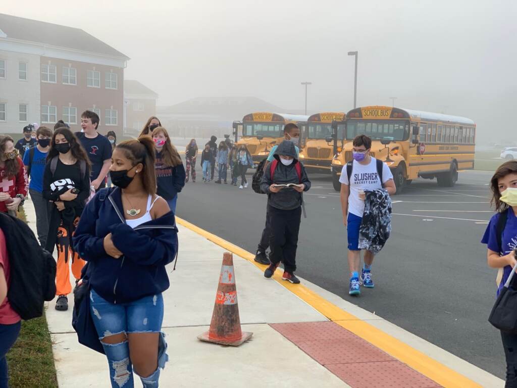 odessa buses Students, wearing masks, walk into school
