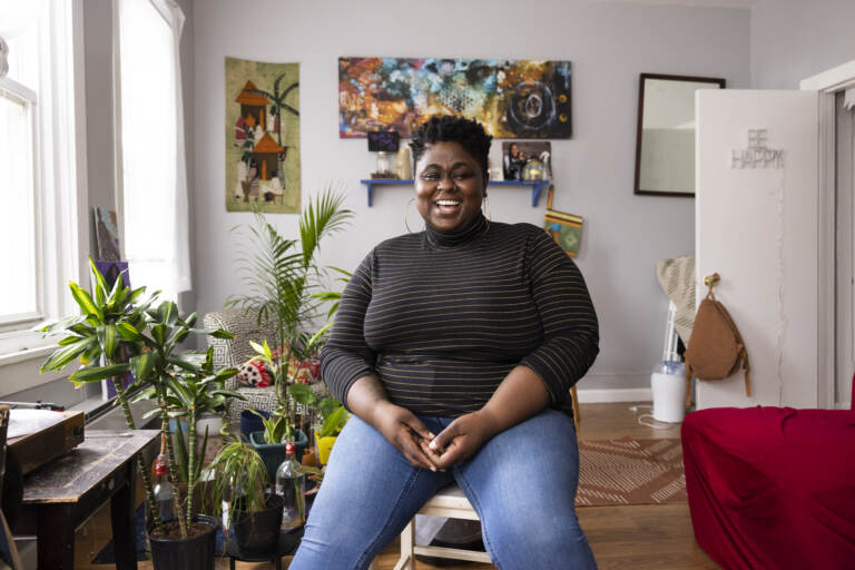 Iresha Picot sits on a stool in her home