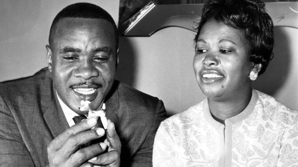 Sonny Liston holds a china dog from his collection as he sits with his wife Geraldine