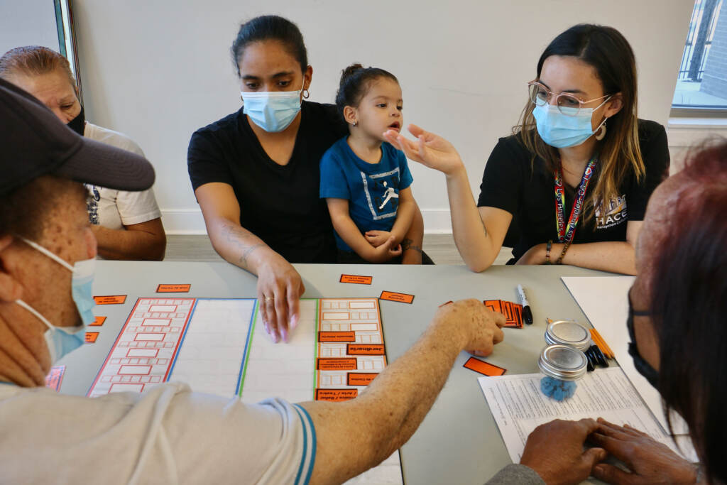 2021 11 08-e lee-philadelphia rivera rec center-community input through board games parenting People wearing face masks play a board game
