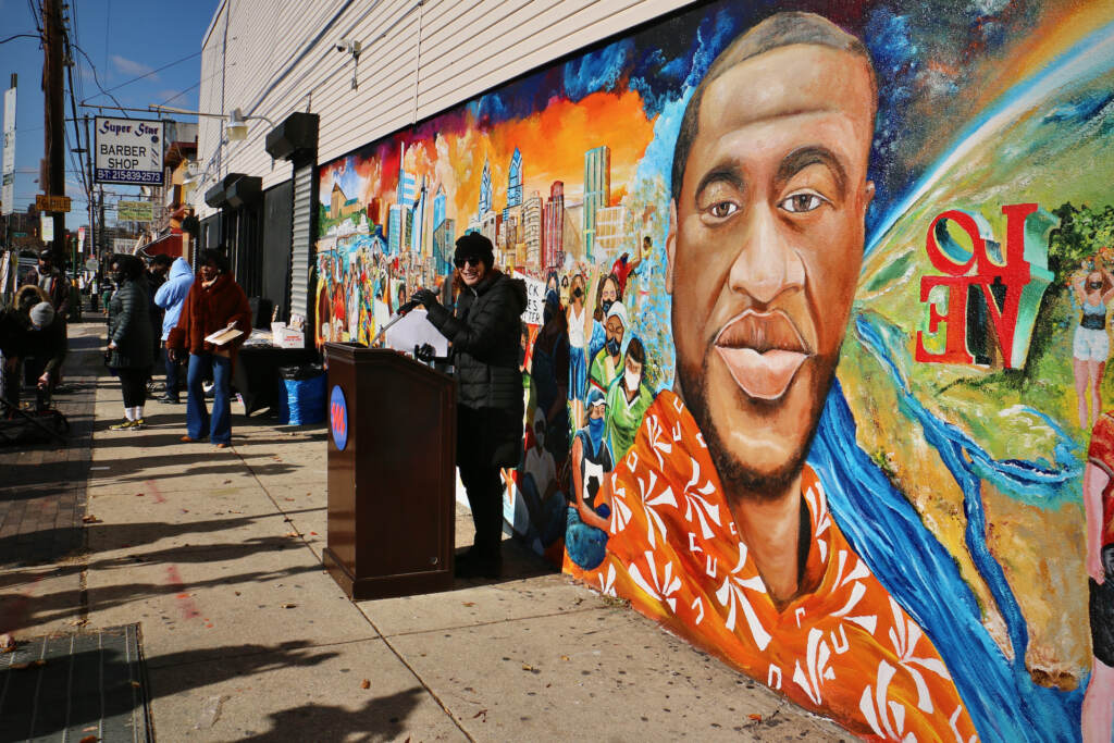 2021 11 23-e lee-jane golden-philadelphia 5th and olney tang pharmacy-george floyd tribute mural Mural Arts Executive Director Jane Golden opens the dedication ceremony for a George Floyd tribute mural in Philadelphia's Olney neighborhood. The mural was painted by local artist Randal Whitfield on the wall of Tang Pharmacy at 5th Street and West Olney Avenue