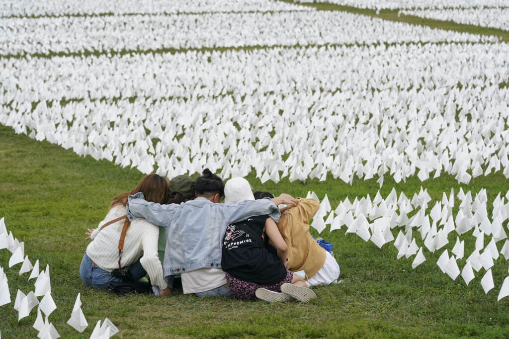 Virus Outbreak Memorials Visitors sit among white flags that are part of artist Suzanne Brennan Firstenberg's