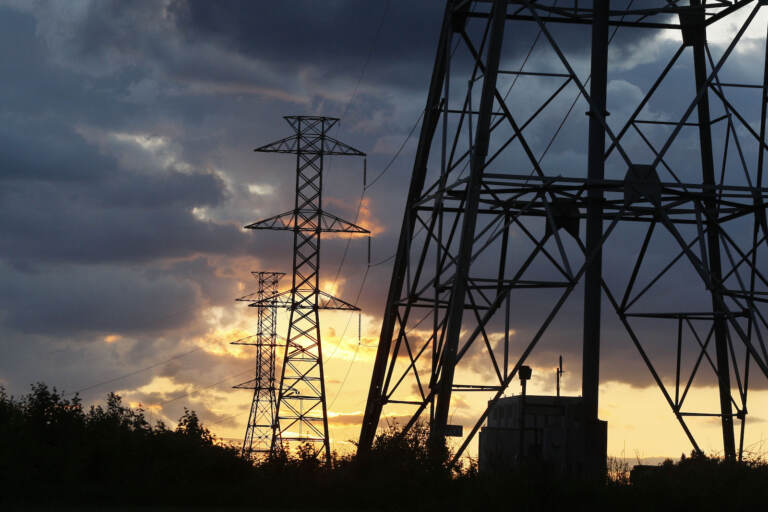 Electrical power generation lines are seen below storm clouds in a rural field near Newtown, Pa. (AP Photo/Mel Evans)