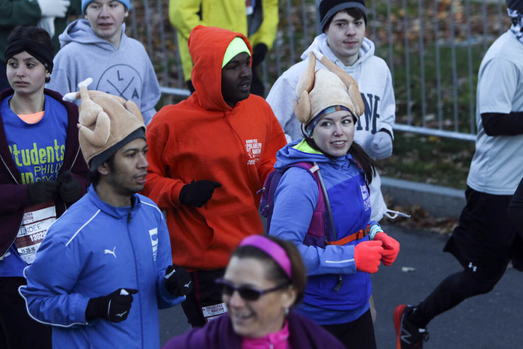 Two runners wear turkey hats as they make their way down the Benjamin Franklin Parkway in Philadelphia at the start of the Philadelphia Marathon, Sunday Nov. 20, 2016