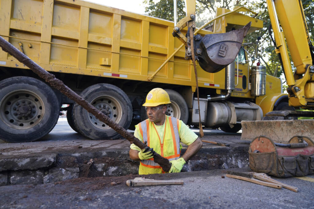A worker removes an old water pipe from underneath the street before replacing it with new copper pipe in Newark, N.J., Thursday, Oct. 21, 2021. (AP Photo/Seth Wenig)