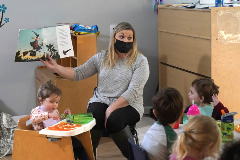 Amy McCoy reads a book to preschoolers as they finish their lunch at her Forever Young Daycare facility, Monday, Oct. 25, 2021, in Mountlake Terrace, Wash. (AP Photo/Elaine Thompson)