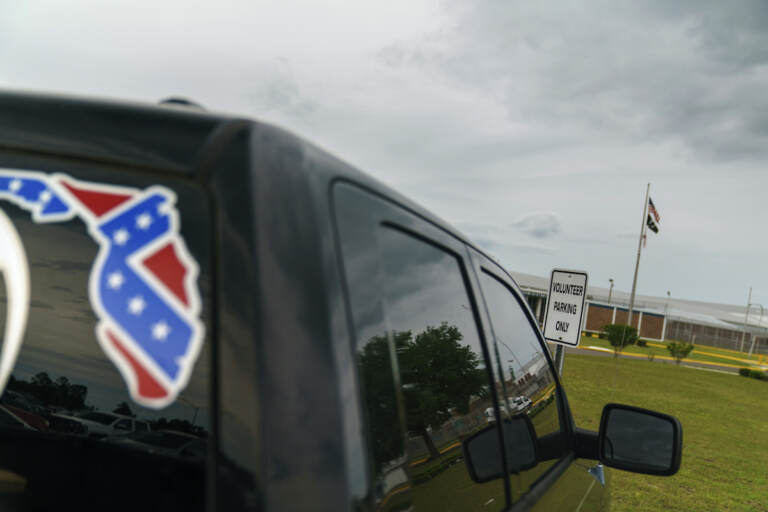  A pickup truck with a Confederate flag-themed decal is parked outside the Reception and Medical Center, the state's prison hospital where new inmates are processed, in Lake Butler, Fla., Friday, April 16, 2021.  (AP Photo/David Goldman, File)