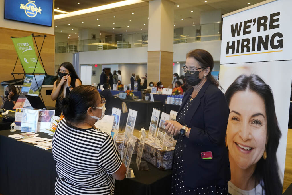 FILE - Marriott human resources recruiter Mariela Cuevas, left, talks to Lisbet Oliveros, during a job fair at Hard Rock Stadium, Friday, Sept. 3, 2021, in Miami Gardens, Fla.  Americans quit their jobs at a record pace for the second straight month in September, while businesses and other employers continued to post a near-record number of available jobs.  (AP Photo/Marta Lavandier, File)