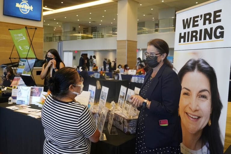 FILE - Marriott human resources recruiter Mariela Cuevas, left, talks to Lisbet Oliveros, during a job fair at Hard Rock Stadium, Friday, Sept. 3, 2021, in Miami Gardens, Fla.  Americans quit their jobs at a record pace for the second straight month in September, while businesses and other employers continued to post a near-record number of available jobs.  (AP Photo/Marta Lavandier, File)