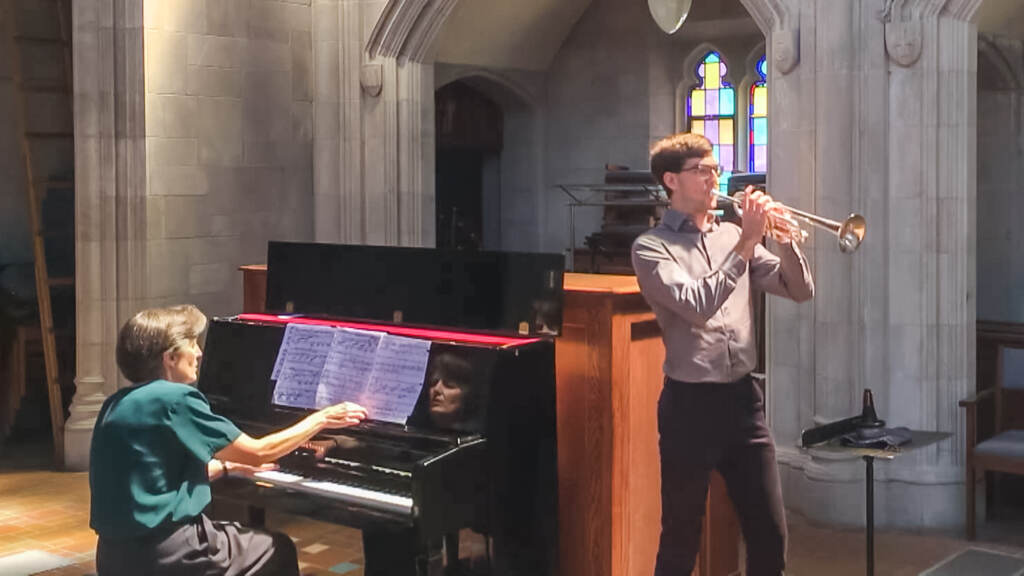 CURTIS-1605 James Vaughen playing the trumpet while his mother, Ann Newton Vaughen, plays the piano in a church