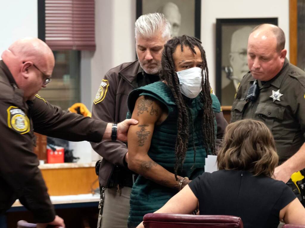 Darrell Brooks, center, makes his initial appearance, Tuesday, Nov. 23, 2021 in Waukesha County Court in Waukesha, Wis. Prosecutors in Wisconsin have charged Brooks with intentional homicide in the deaths of at least five people who were killed when an SUV was driven into a Christmas parade