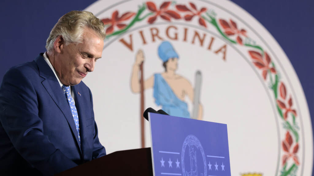 Terry McAuliffe speaks from a podium at a rally