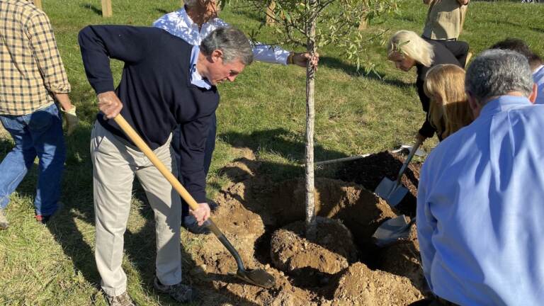 Delaware Gov. John Carney helps plant a tree at Lt. Joseph L. Szczerba Memorial Park