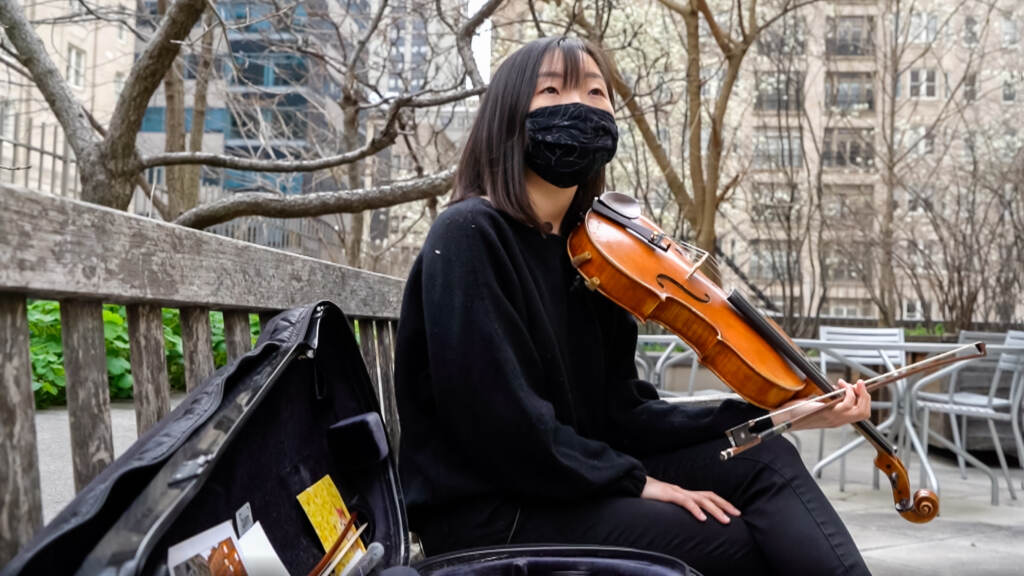 OSC-1604 Grace Takeda wearing a mask playing her violin outside