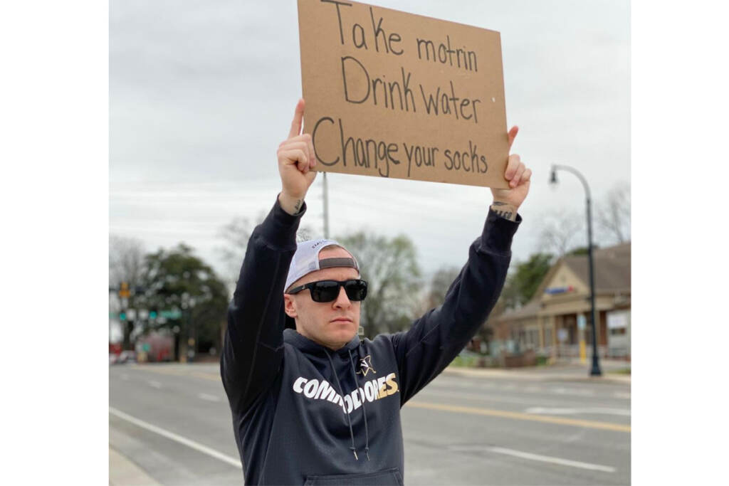 ZBvetwithasign1200 Zachary Bell wants to create a positive online community with fellow veterans through humor, inside jokes, and messages about mental health. (Courtesy of Zachary Bell)