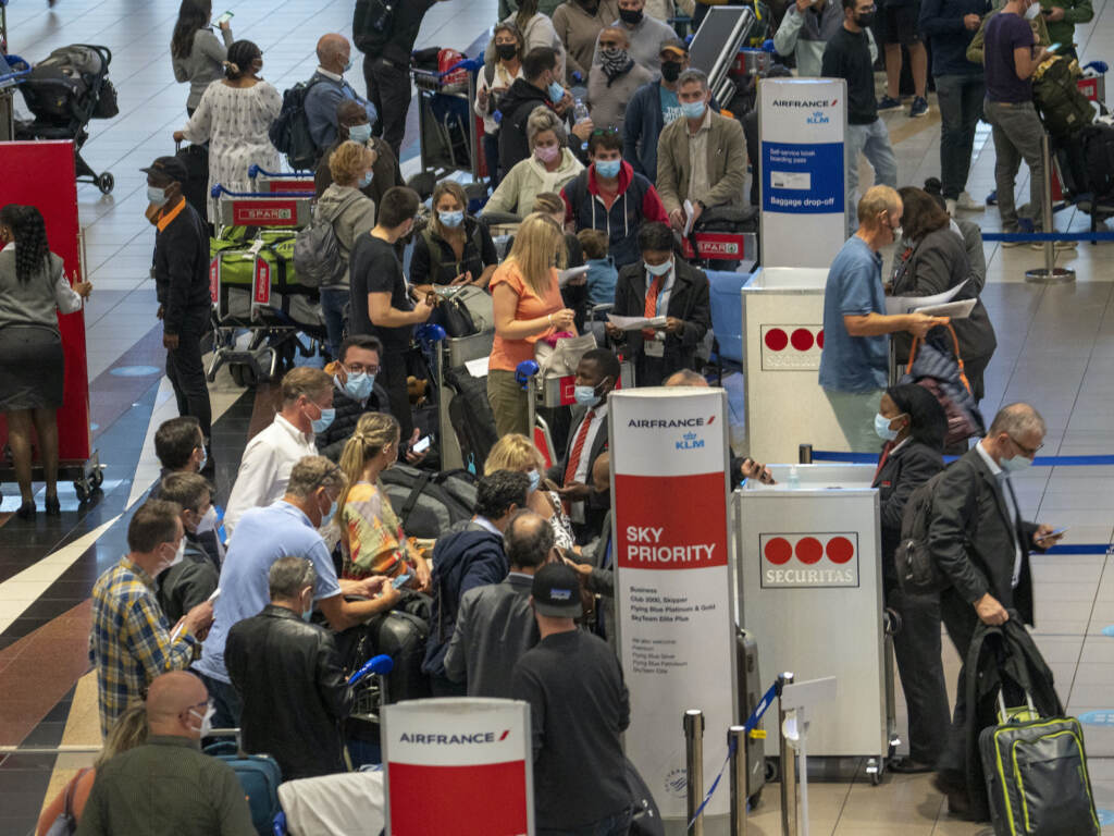 Virus Outbreak New Variant People line up to get on a flight