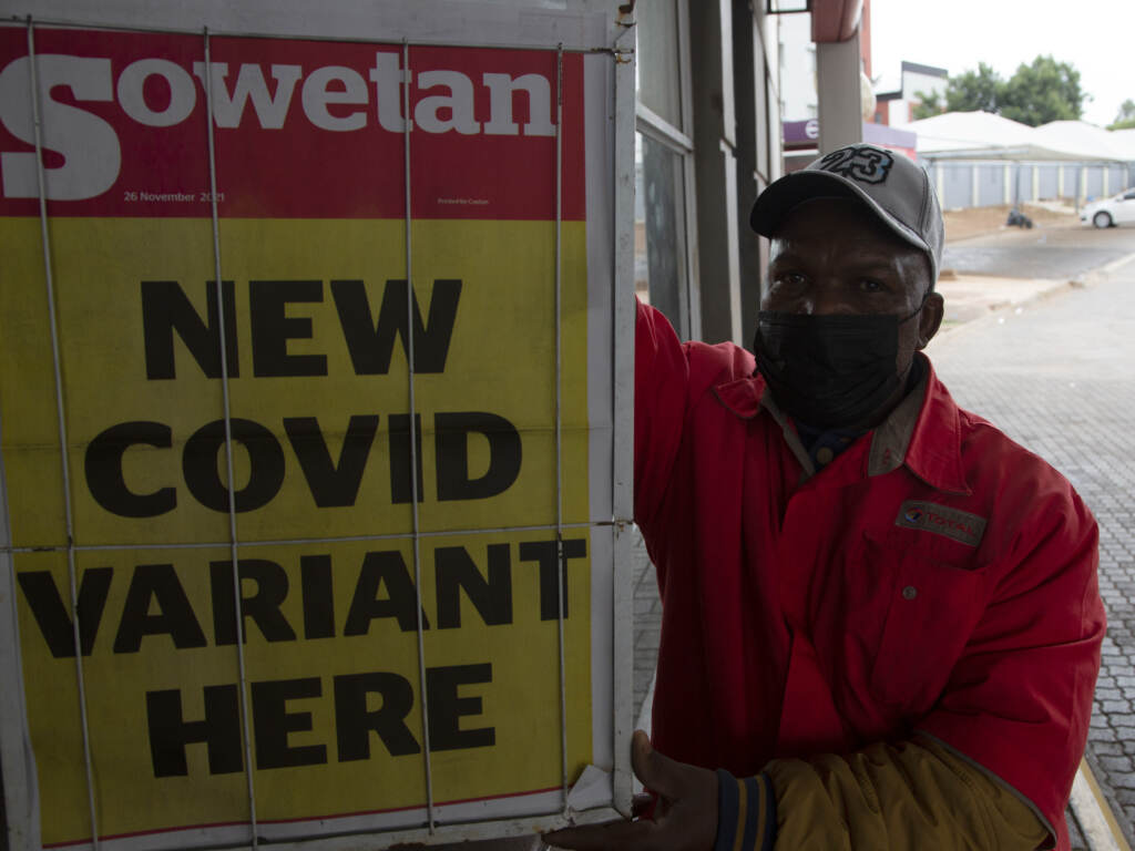 A gas station attendant stands next to a newspaper headline in Pretoria, South Africa, on Saturday. The new omicron variant has spread from South Africa to parts of Europe, and as far as Hong Kong. A petrol attendant stands next to a newspaper headline in Pretoria, South Africa, Saturday, Nov. 27, 2021. As the world grapples with the emergence of the new variant of COVID-19, scientists in South Africa — where omicron was first identified — are scrambling to combat its spread across the country. (AP Photo/Denis Farrell)