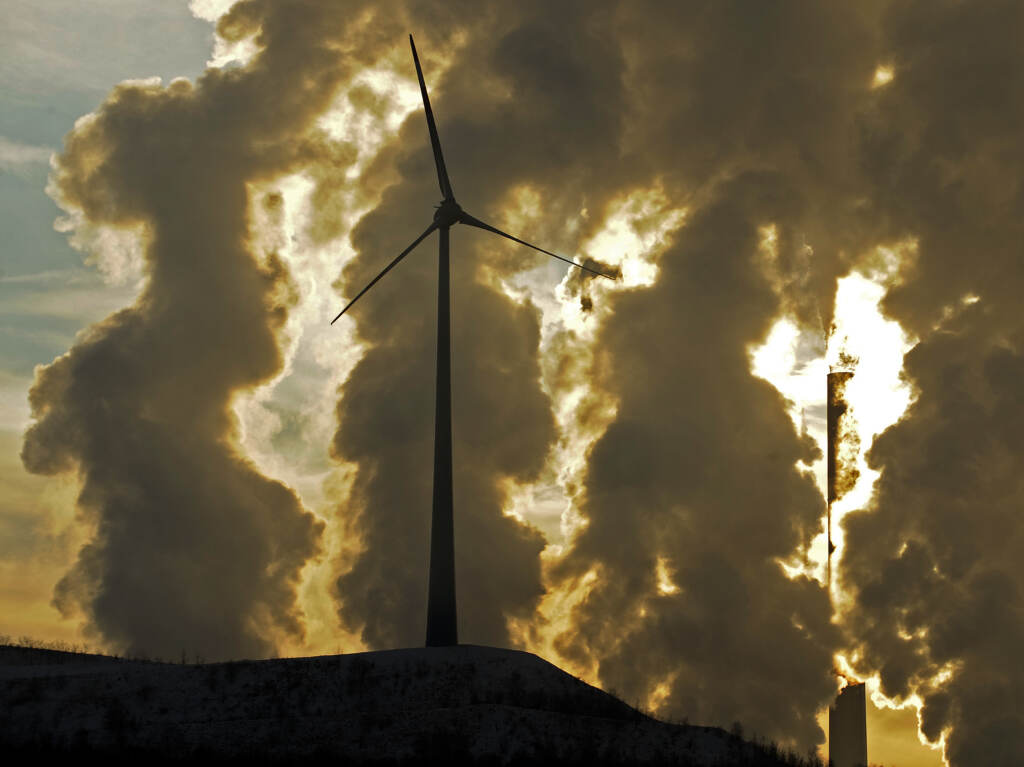A wind turbine in front of a steaming coal power plant in Gelsenkirchen, Germany in 2010. New reports find countries’ latest promises to cut climate emissions are still not enough to avoid the worst impacts from warming. A wind turbine in front of a steaming coal power plant