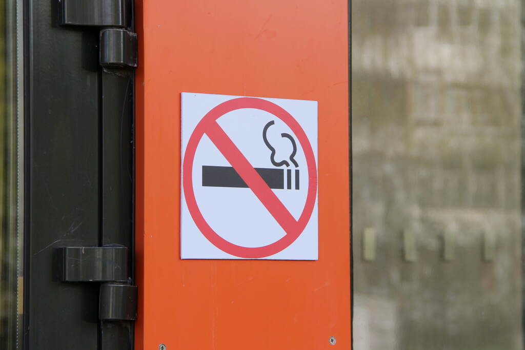 No Smoking Sign On Orange Wall, Concept Of Health Care, Smoking Harm reduction advocates arguedvthat banning smoking in treatment would act as yet another obstacle to recovery. (stasokulov / BigStock)