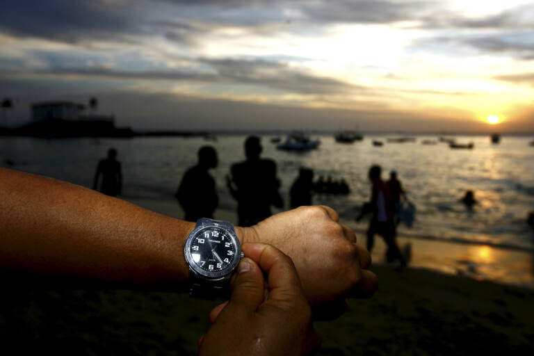 People are seen adjusting the clock during the summer time period in Salvador, Brazil
