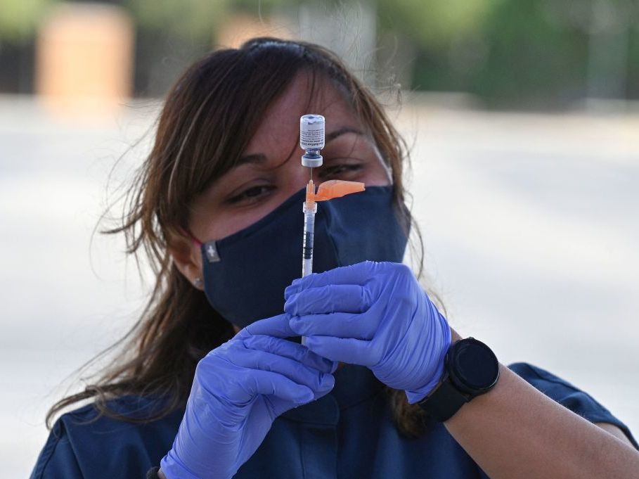 Booster shots are authorized for all U.S. adults, but some are wondering if they need them. A nurse fills a syringe with a Pfizer-BioNTech dose at a pop-up vaccine clinic in the Arleta neighborhood of Los Angeles. A nurse fills a syringe with Pfizer-BioNTech's COVID-19 vaccine