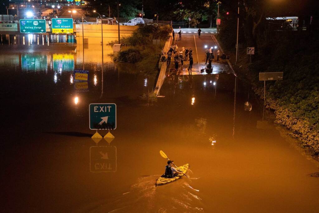 A kayaker paddles down an interstate in Pennsylvania after flooding from Hurricane Ida. Several dozen people died, some in cars and basement apartments, during extreme flash flooding. A kayaker paddles down a portion of I-676