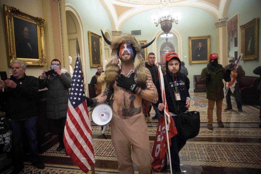 gettyiJacob Chansley, the self-styled “QAnon shaman,” confronts U.S. Capitol Police officers during the January 6 insurrection.mages-1294949487size_custom-d1d02b295e7b2ca44a0aded27ebe5ecf0317f7de-s1600-c85 Jacob Chansley, the self-styled