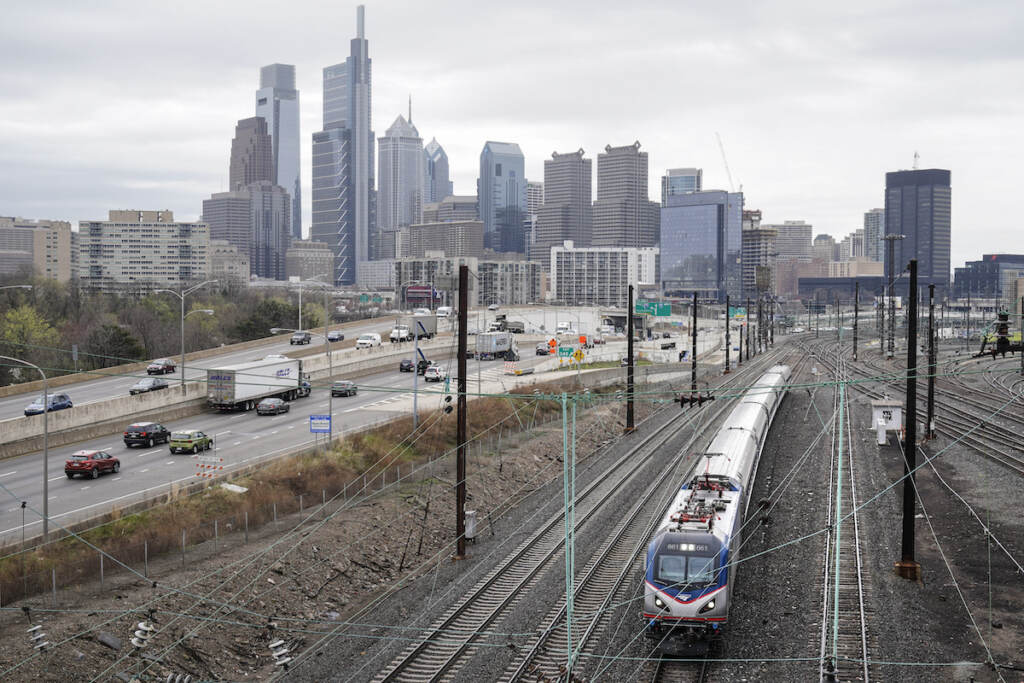 Biden Infrastructure An Amtrak train departs 30th Street Station moving parallel to motor vehicle traffic on Interstate 76 in Philadelphia. (AP Photo/Matt Rourke)