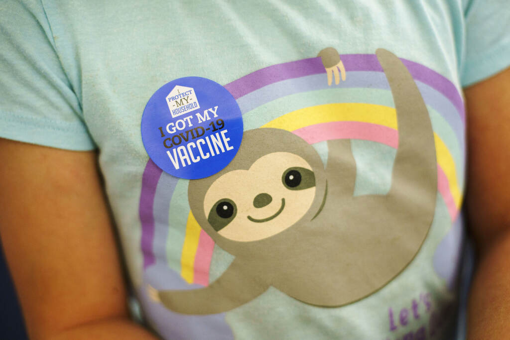 Virus Outbreak Kids Vaccine A closeup of a child's t-shirt, with a sticker visible that says,