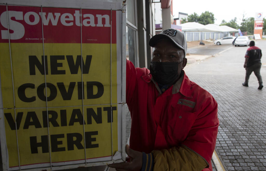 Virus Outbreak New Variant A petrol attendant uses next to a newspaper headline in Pretoria, South Africa, Saturday, Nov. 27, 2021. As the world grapples with the emergence of the new variant of COVID-19, scientists in South Africa — where omicron was first identified — are scrambling to combat its spread across the country. (AP Photo/Denis Farrell)