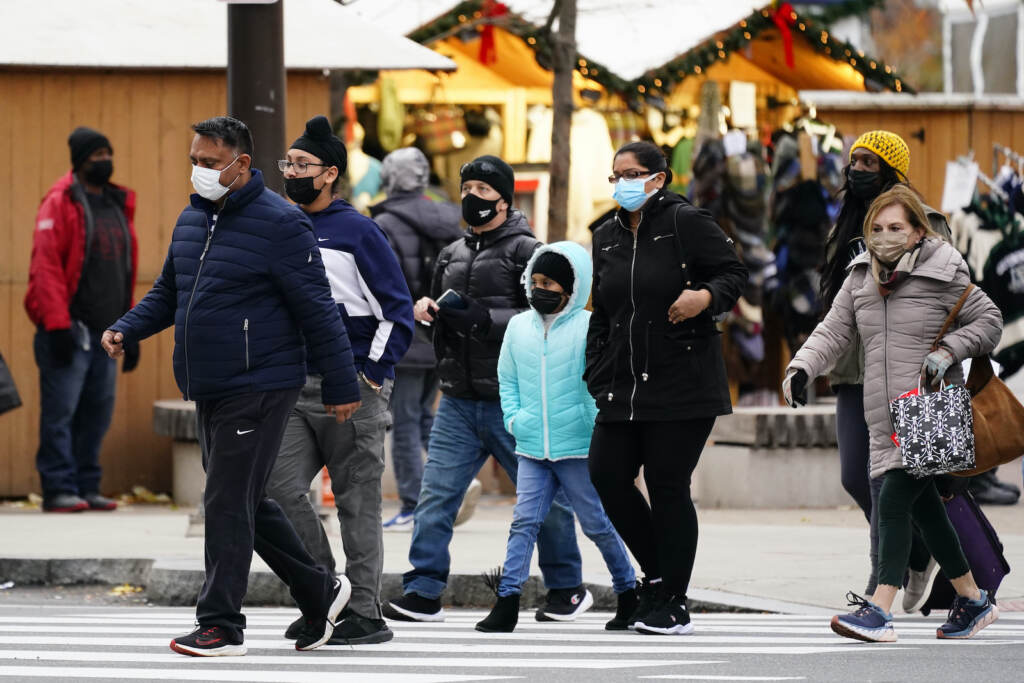 People wearing face masks walk through Philadelphia