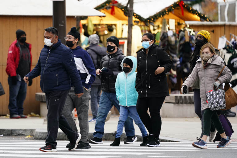 People wearing face masks walk through Philadelphia