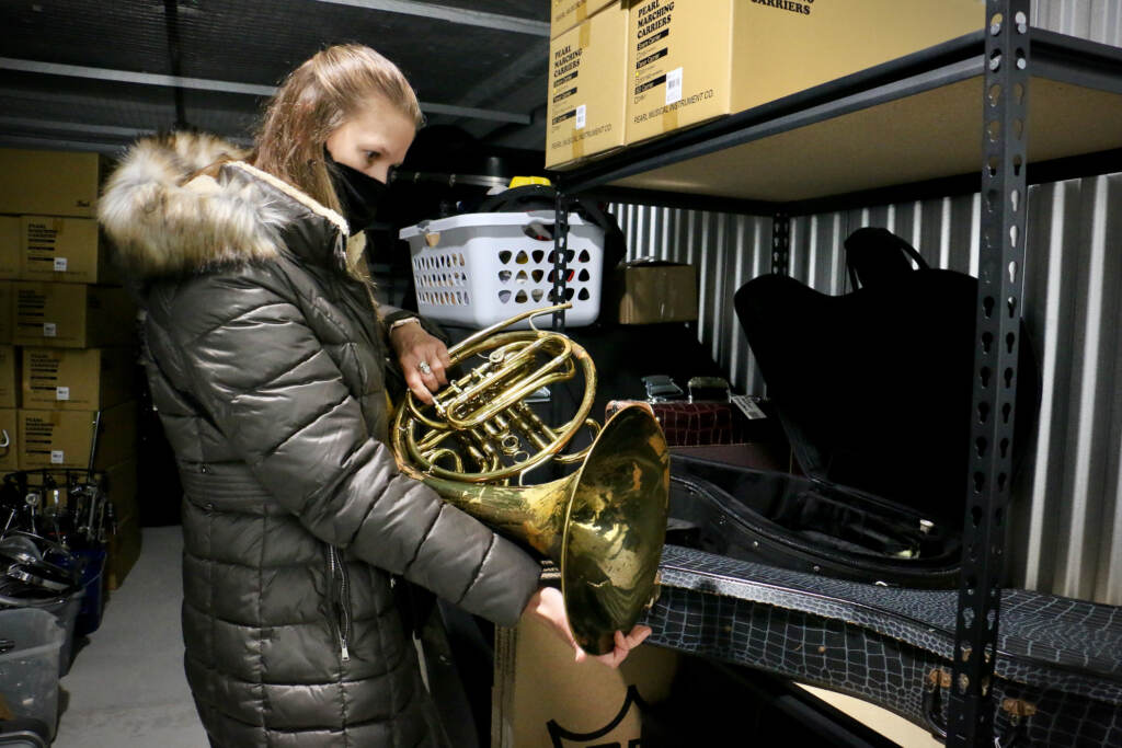 2021 11 30-e lee-kelly knittle-philadelphia musicopia-musical instrument giveaway MaST Charter School music teacher Kelly Knittle evaluates a French horn as she selects instruments for her students from a trove of donated instruments offered by Musicopia