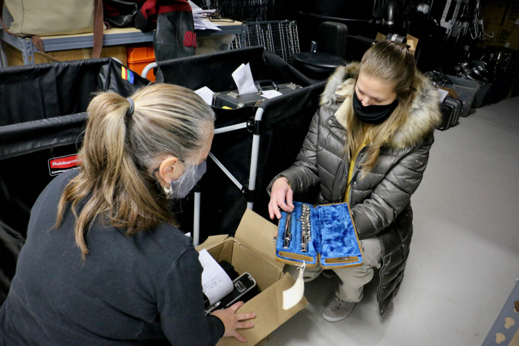 Musicopia's Leslie Macedo sorts through flutes with MaST Charter School music teacher Kelly Knittle
