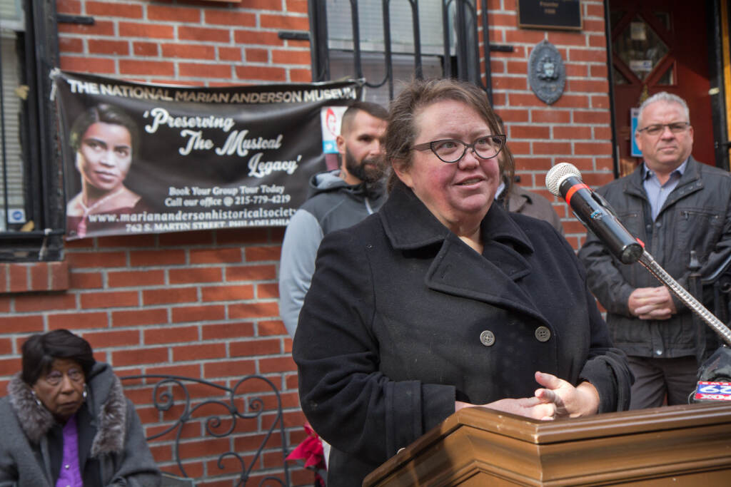 Jennifer Robinson speaks from a podium outside the Marian Anderson museum