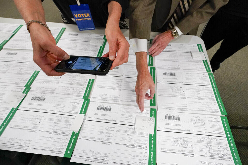 Election 2020-Voter Fraud A canvas observer photographs Lehigh County provisional ballots as vote counting in the general election continues, Nov. 6, 2020, in Allentown, Pa. A review by The Associated Press in the six battleground states disputed by former President Trump has found fewer than 475 cases of potential voter fraud, a minuscule number that would have made no difference in the 2020 presidential election. (AP Photo/Mary Altaffer, file)