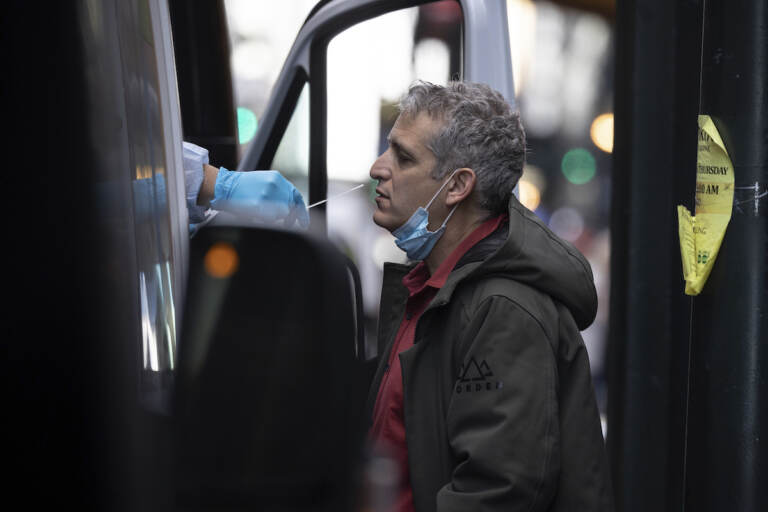 A person takes COVID-19 test at mobile testing site near Grand Central Terminal on Friday, Dec. 3, 2021, in New York. The omicron variant of COVID-19, which had been undetected in the U.S. before the middle of this week, had been discovered in at least five states by the end of Thursday, showing yet again how mutations of the virus can circumnavigate the globe with speed and ease