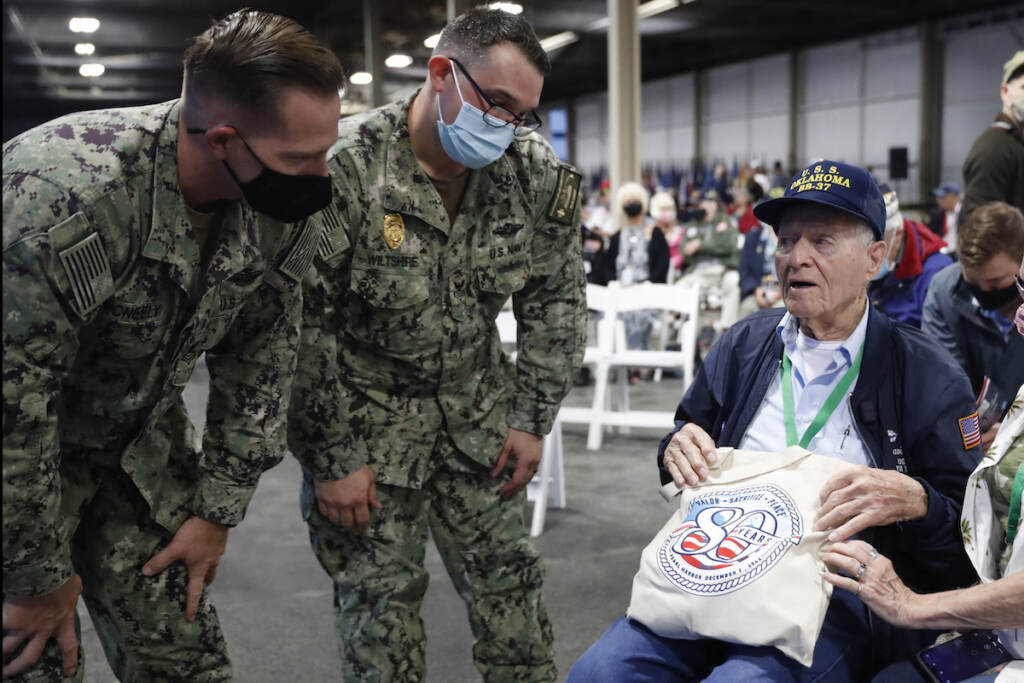 Pearl Harbor Anniversary Pearl Harbor survivor and World War II Navy veteran David Russell, 101, of Albany, NY, shows off his commemorative bag to two military personnel before the start of the 80th Pearl Harbor Anniversary ceremony at Joint Base Pearl Harbor-Hickam, Tuesday, Dec. 7th, 2021, in Honolulu