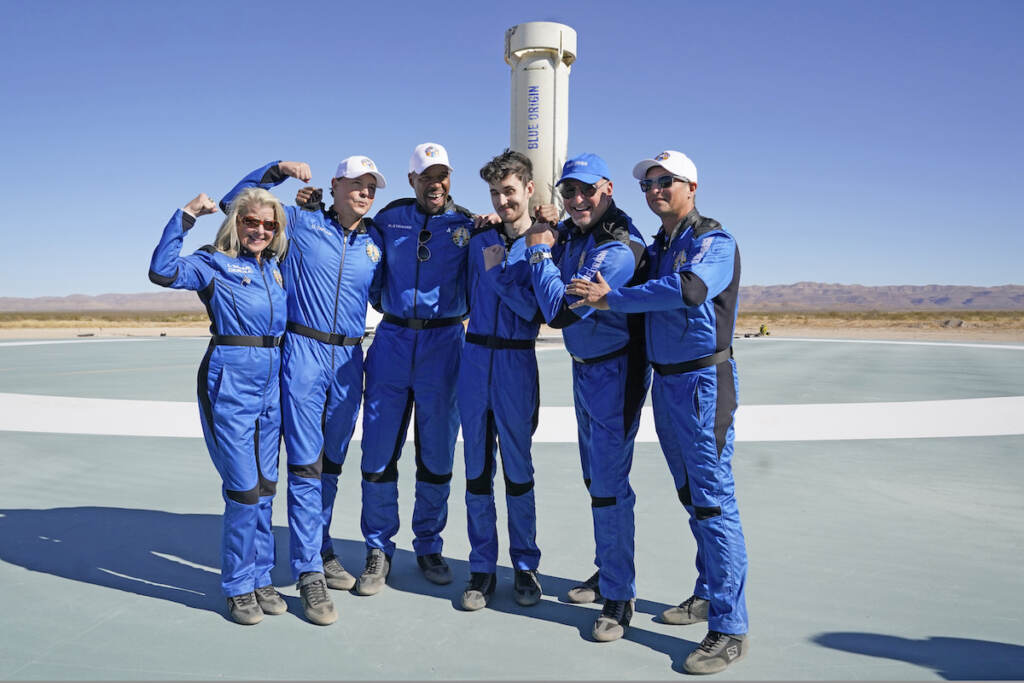Blue Origin's latest space passengers from left, Laura Shepard Churchley, Dylan Taylor, Michael Strahan, Cameron Bess, Lane Bess, and Evan Dick pose for a photo in front of the booster rocket at the spaceport near Van Horn, Texas, Saturday, Dec. 11, 2021