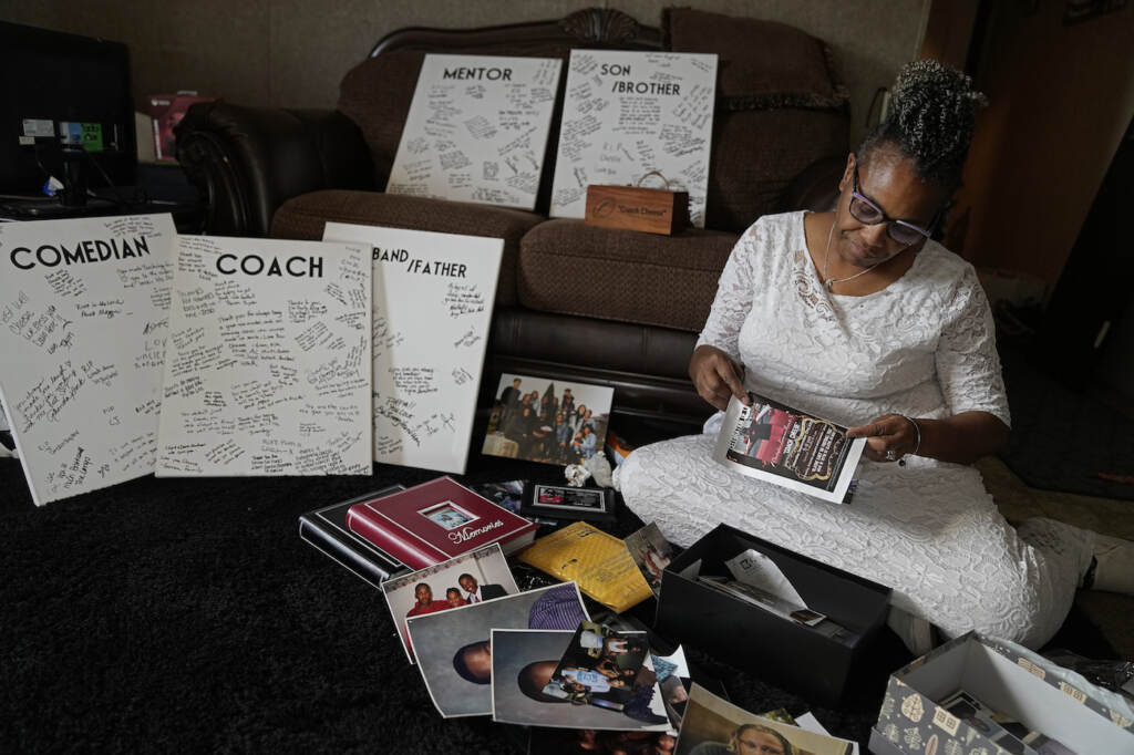 Carolyn Burnett Carolyn Burnett sorts through mementos to select items to commemorate her son Chris Burnett Sunday, Dec. 5, 2021, in Olathe, Kan. Chris Burnett, who coached football at Olathe East High School, died of COVID-19 on Sept. 11 at The age of 34. (AP Photo/Charlie Riedel)
