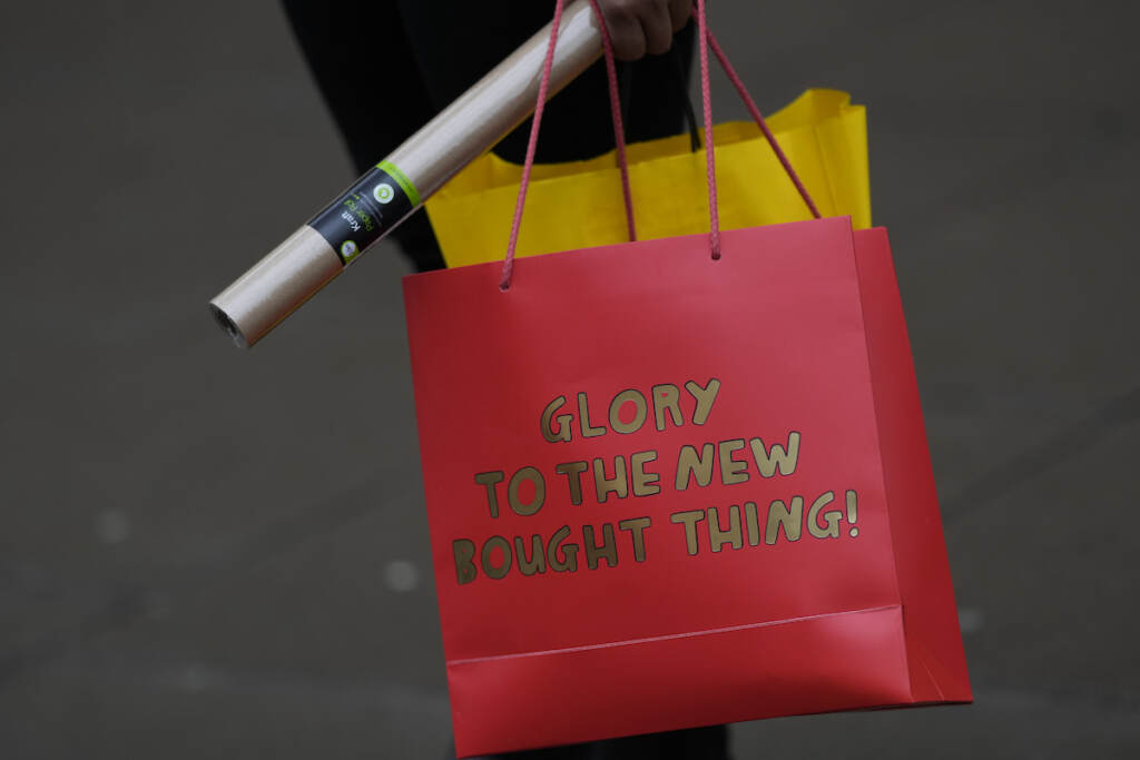 Virus Outbreak Britain A shopper carries her bags after leaving a department store in Oxford Street on Christmas Eve in London, Friday, Dec. 24, 2021. The emergence of the new COVID-19 omicron variant and the world's desperate and likely futile attempts to keep it at bay are reminders of what scientists have warned for months: The coronavirus will thrive as long as vast parts of the world lack vaccines