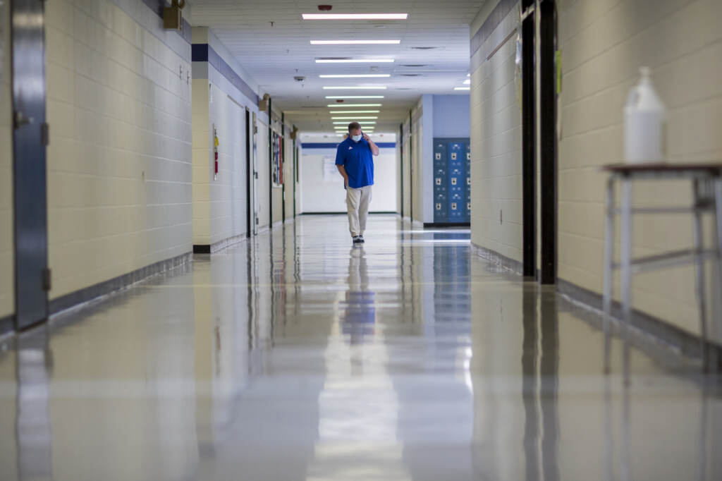A middle school principal walks the empty halls of his school