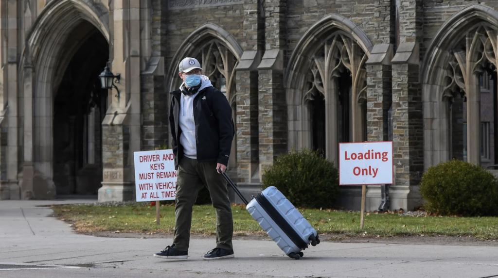 Screen Shot 2021-12-19 at 10.38.29 AM A Cornell University student waits for a ride with luggage in tow at the campus in Ithaca, N.Y., Thursday, Dec. 16. Cornell University abruptly shut down all campus activities on Tuesday and moved final exams online after hundreds of students tested positive over three days.
Heather Ainsworth/AP