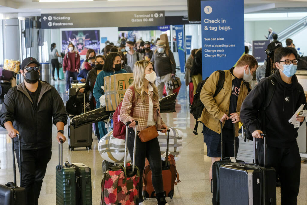 Virus Outbreak California Holiday Travelers Travelers wearing face masks line to check in at the Los Angeles International Airport