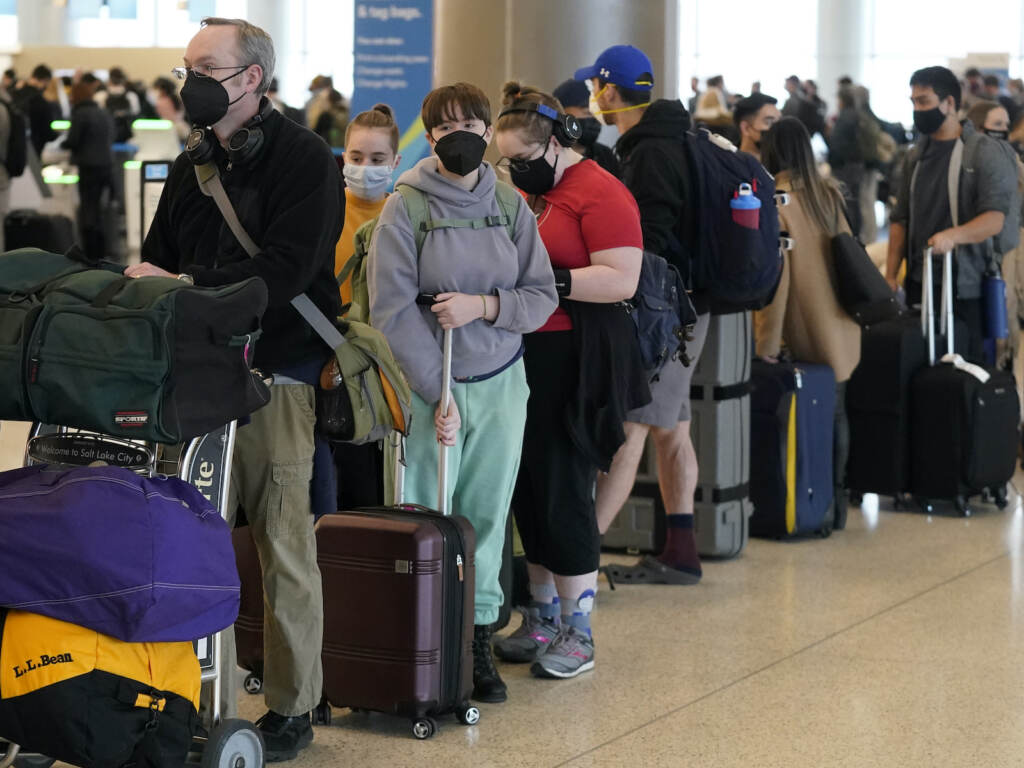Travelers wait in the ticketing line