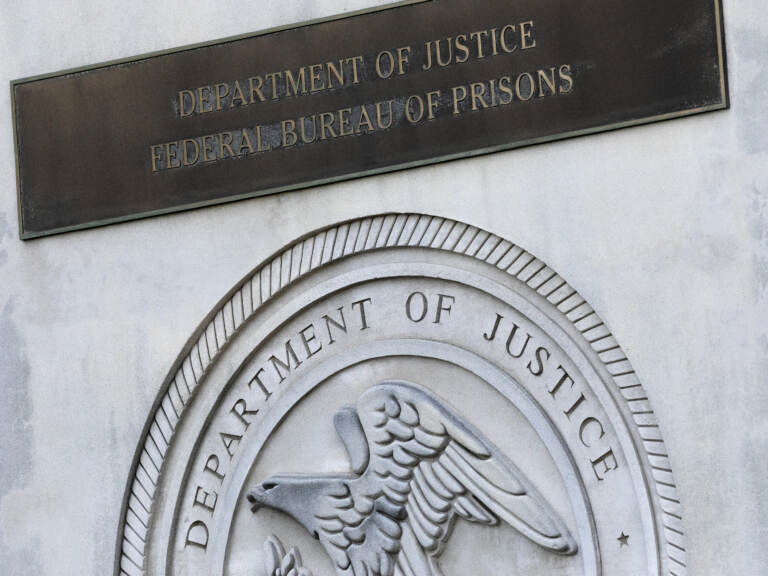 In this July 6, 2020, file photo a sign for the Department of Justice Federal Bureau of Prisons is displayed at the Metropolitan Detention Center in the Brooklyn borough of New York. While most criminal justice overhauls require action from local officials or legislation, reforming the federal prison system is something President Joe Biden and his Justice Department control. (AP Photo/Mark Lennihan, File)