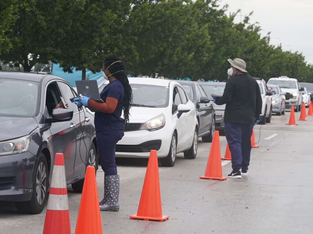 Employees of Nomi Health check in a long line of people for COVID-19 tests on Tuesday in North Miami, Fla. Employees of Nomi Health check in a long line of people for COVID-19 tests, Tuesday, Dec. 21, 2021, in North Miami, Fla. President Biden is promising to open new COVID-19 testing sites and distribute hundreds of millions of free rapid tests as part of a plan to fight surging infections, but the stepped up efforts won’t come in time for people scouring drug stores or waiting hours in the cold to find out if they’re infected ahead of the holidays. (AP Photo/Marta Lavandier)