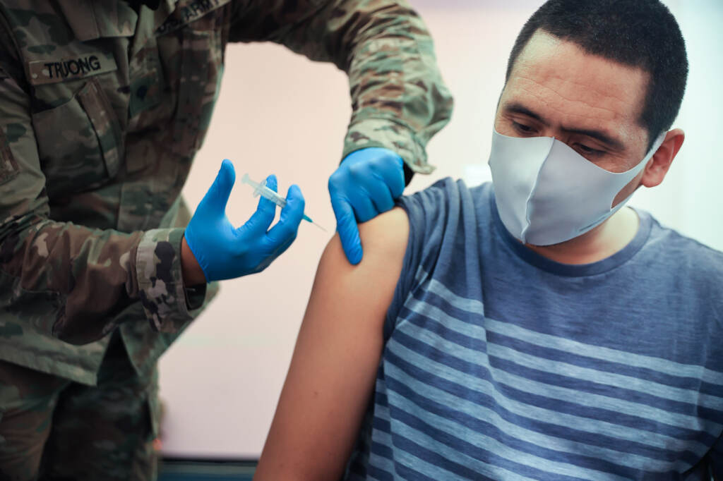 James Truong (L) administers a Moderna coronavirus vaccine