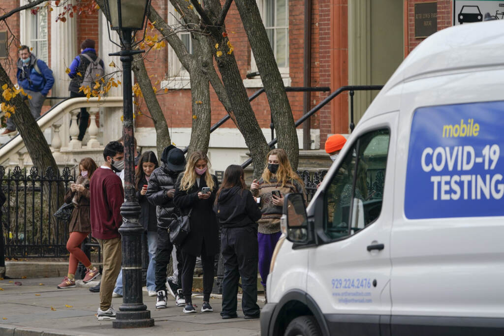 Pedestrians wait in line to get tested for COVID-19